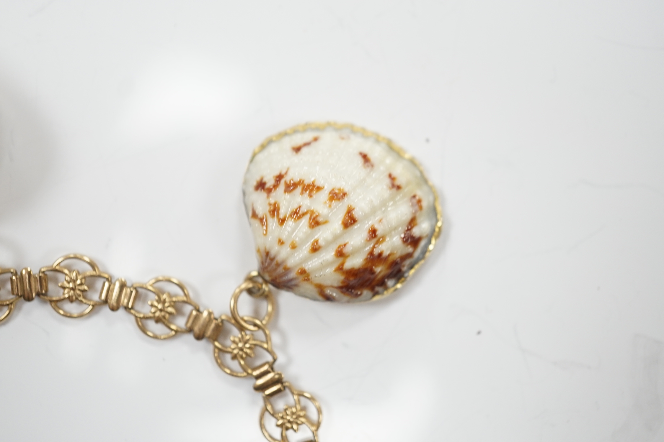 A modern 9ct gold charm bracelet hung with four shell charms, gross weight 19.1 grams.